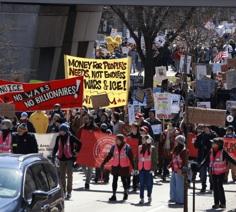 This image depicts Madison DSA members at the recent No Kings protest. Some prominent signs say, "No ICE, No Wars, No Billionaires," and "Money for People's Needs, not endless wars and ice!"